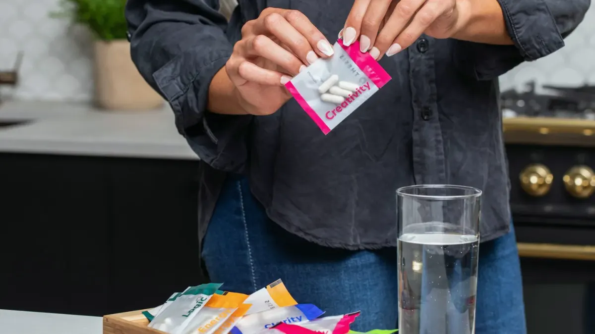 A dog owner comparing a chew treat and a tablet supplement in an open palm
