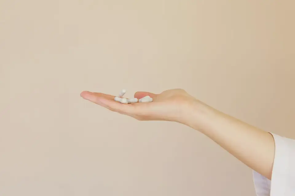 Hand holding two dog supplement bottles side by side for comparison